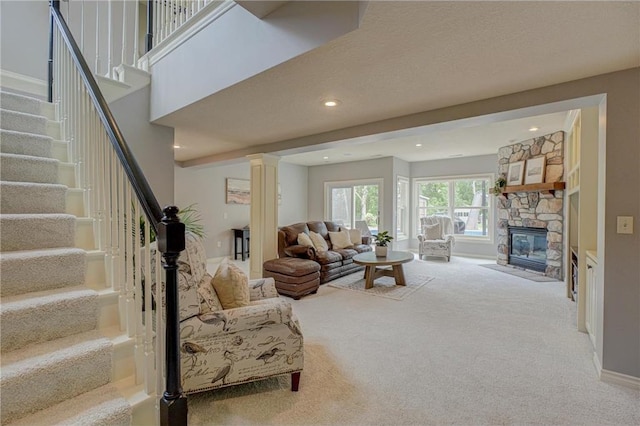 278 Saint Annes Pkwy, Hudson, WI 54016 - living room with carpet flooring, stairway, a fireplace, ornate columns, and recessed lighting