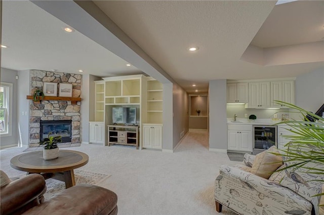 278 Saint Annes Pkwy, Hudson, WI 54016 - living area with beverage cooler, light colored carpet, baseboards, a stone fireplace, and recessed lighting