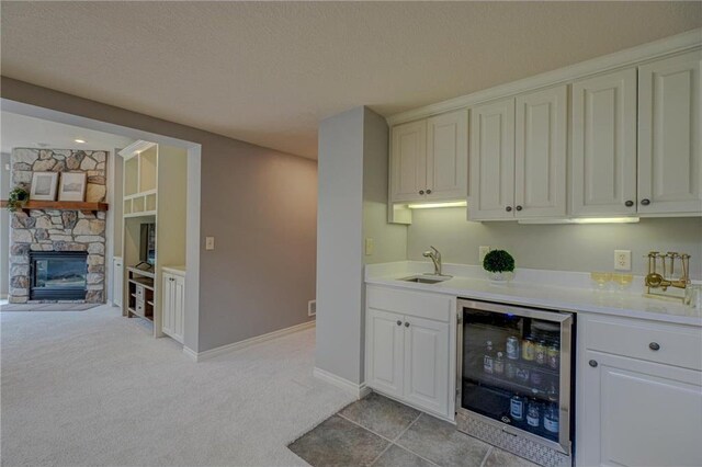 278 Saint Annes Pkwy, Hudson, WI 54016 - indoor bar featuring beverage cooler, a stone fireplace, light colored carpet, a textured ceiling, and baseboards