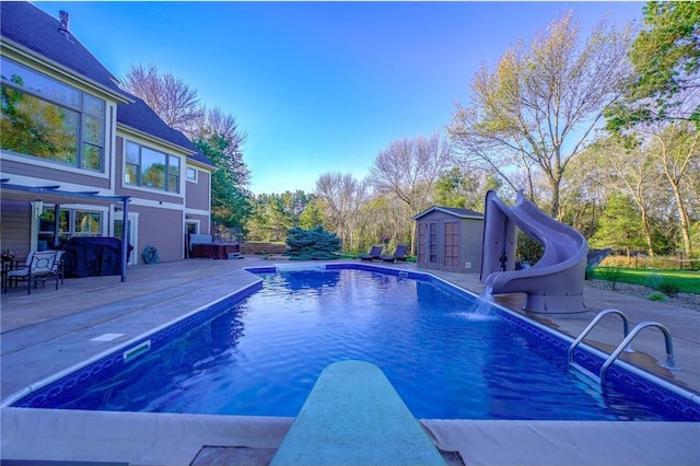 278 Saint Annes Pkwy, Hudson, WI 54016 - swimming pool with a diving board, a water slide, an outdoor structure, and a patio area
