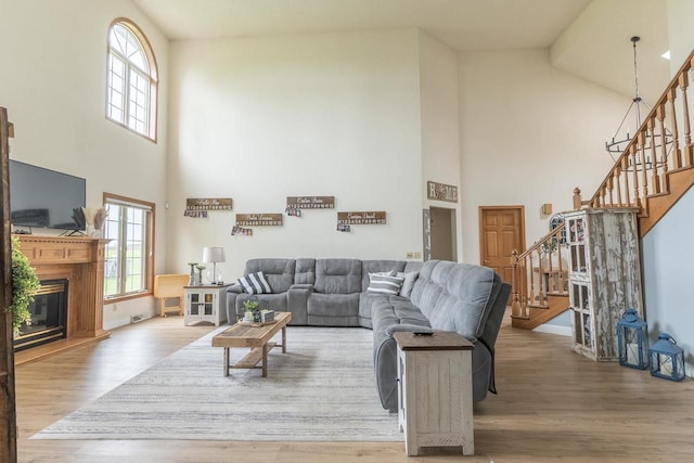 315 N 7th St, Colby, WI 54421 - living room with high vaulted ceiling, stairs, healthy amount of natural light, wood finished floors, and a glass covered fireplace