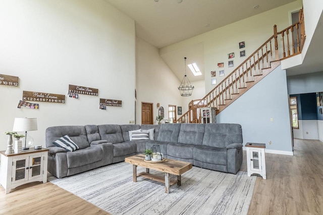 315 N 7th St, Colby, WI 54421 - living room featuring stairs, high vaulted ceiling, wood finished floors, a skylight, and baseboards