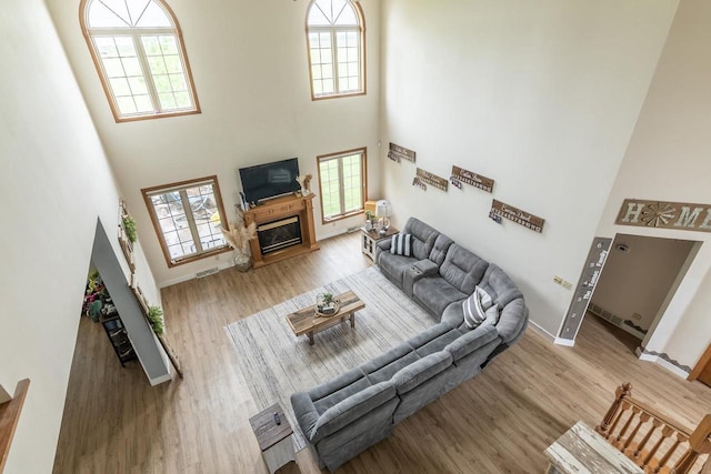 315 N 7th St, Colby, WI 54421 - living area featuring a towering ceiling, wood finished floors, healthy amount of natural light, and a glass covered fireplace
