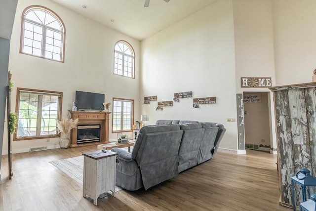 315 N 7th St, Colby, WI 54421 - living room with a towering ceiling, wood finished floors, a ceiling fan, baseboards, and a glass covered fireplace