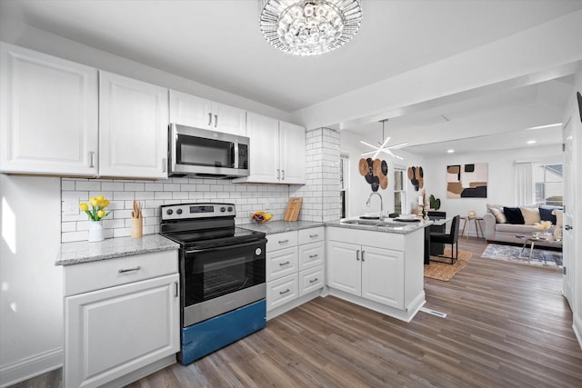 4193 N 19th Pl, Milwaukee, WI 53209 - kitchen with appliances with stainless steel finishes, a sink, a peninsula, a chandelier, and dark wood finished floors