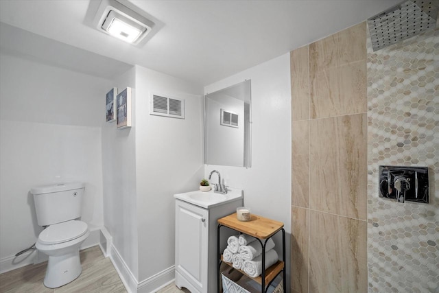 4193 N 19th Pl, Milwaukee, WI 53209 - full bath with toilet, vanity, tiled shower, baseboards, and wood finished floors