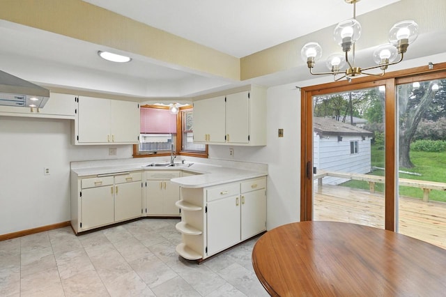 4349 N 80th St, Milwaukee, WI 53222 - kitchen featuring light countertops, a sink, a chandelier, decorative light fixtures, and a tray ceiling