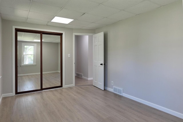 2107 W Grand Ave, Beloit, WI 53511 - unfurnished bedroom featuring light wood-type flooring, baseboards, a closet, and a drop ceiling