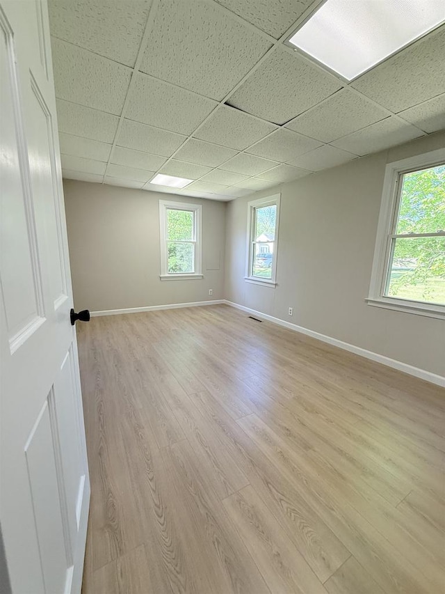 2107 W Grand Ave, Beloit, WI 53511 - spare room with a paneled ceiling, light wood-style floors, and baseboards