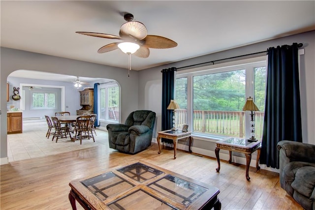 8054 223rd St, Cadott, WI 54727 - living room with arched walkways, a ceiling fan, light wood-style floors, and healthy amount of natural light