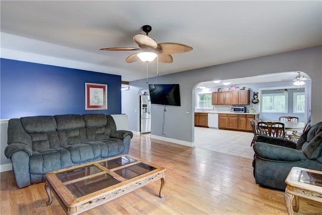 8054 223rd St, Cadott, WI 54727 - living area featuring a ceiling fan, arched walkways, baseboards, and light wood-type flooring