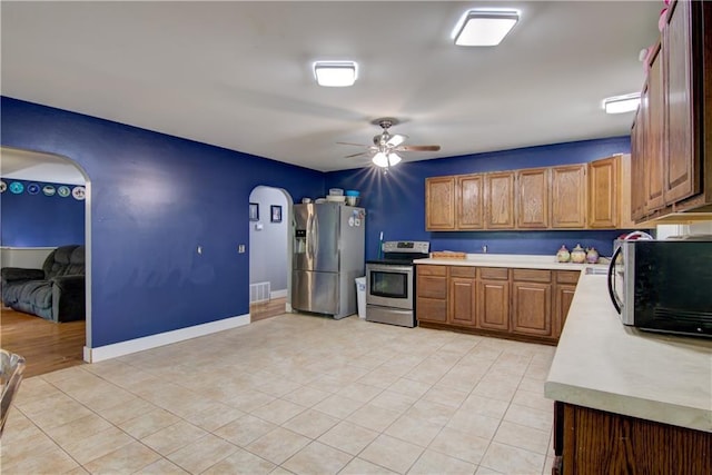8054 223rd St, Cadott, WI 54727 - kitchen featuring appliances with stainless steel finishes, arched walkways, light countertops, ceiling fan, and light tile patterned floors