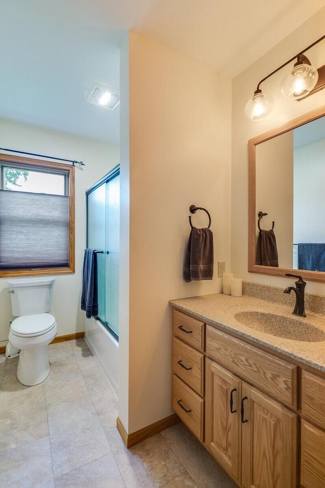 2424 Glendale Ave, La Crosse, WI 54601 - bathroom with vanity, toilet, combined bath / shower with glass door, and baseboards