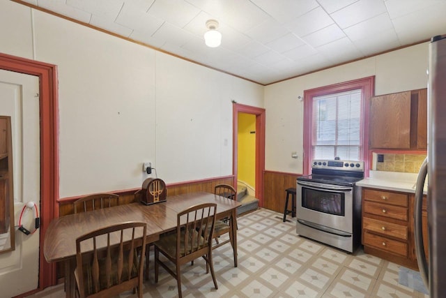 146 S Washington St, Waterloo, WI 53594 - kitchen featuring stainless steel electric range, wainscoting, light countertops, light flooring, and ornamental molding