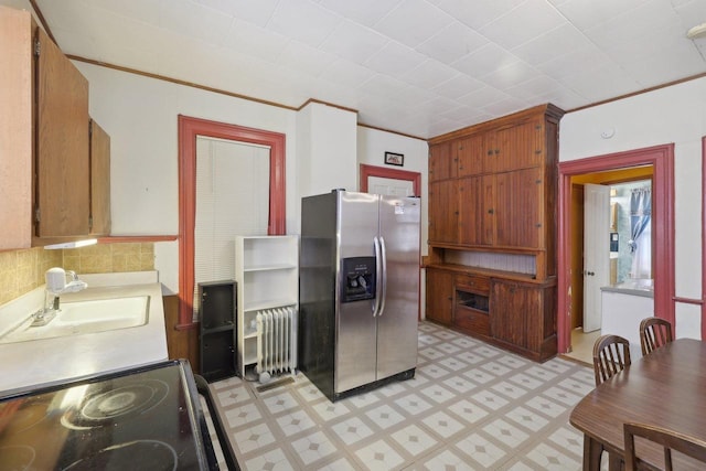 146 S Washington St, Waterloo, WI 53594 - kitchen featuring stainless steel refrigerator with ice dispenser, radiator heating unit, a sink, light floors, and black range with electric stovetop
