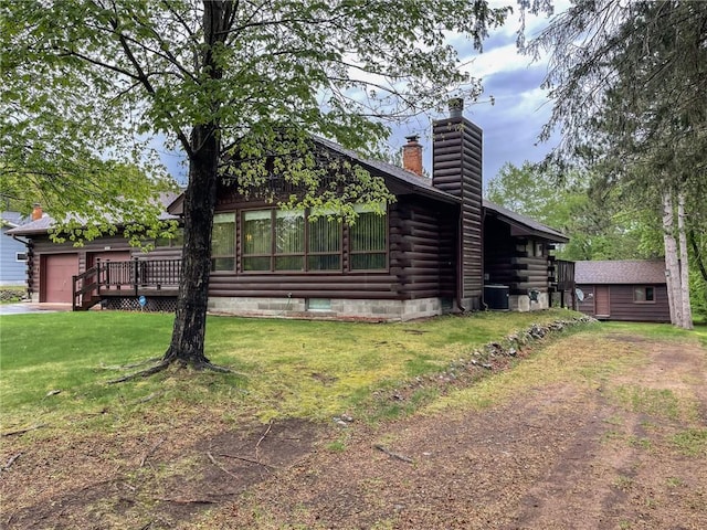 10790 Beal Ave, Hayward, WI 54843 - view of front of property featuring a chimney, log siding, a front yard, a garage, and a wooden deck