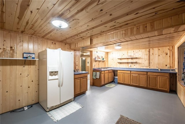 10790 Beal Ave, Hayward, WI 54843 - kitchen with white refrigerator with ice dispenser, wood walls, concrete flooring, wood ceiling, and brown cabinets