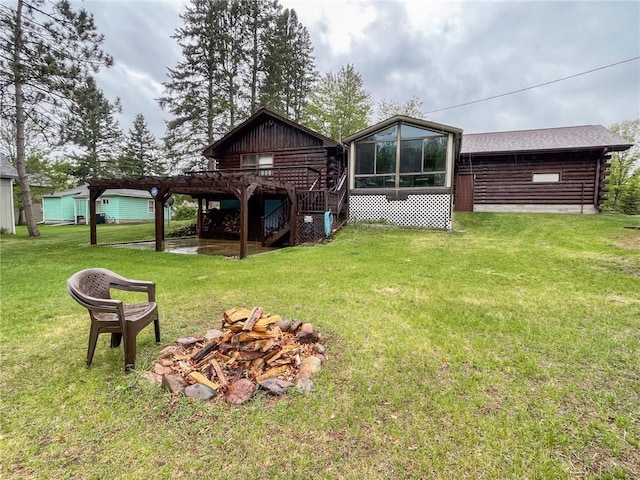 10790 Beal Ave, Hayward, WI 54843 - rear view of property featuring an outdoor fire pit, stairway, a lawn, log siding, and a deck