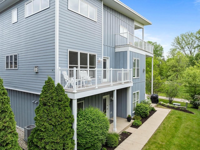 485 Mill St, Fontana, WI 53125 - back of house with board and batten siding, a balcony, central air condition unit, and a lawn