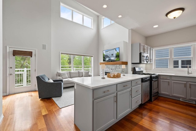 485 Mill St, Fontana, WI 53125 - kitchen featuring gray cabinetry, gas stove, a high ceiling, a sink, and a peninsula