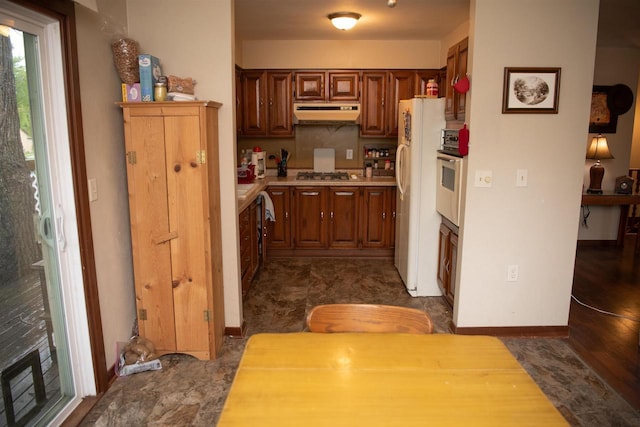 207 S Beach St, Plainfield, WI 54966 - kitchen with freestanding refrigerator, stainless steel gas stovetop, light countertops, under cabinet range hood, and wall oven