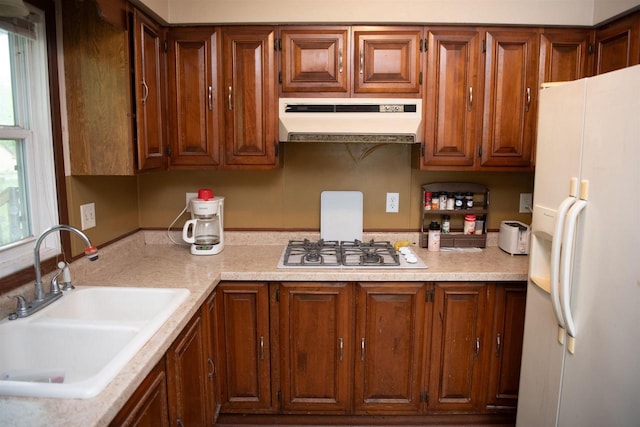 207 S Beach St, Plainfield, WI 54966 - kitchen with under cabinet range hood, white refrigerator with ice dispenser, a sink, gas cooktop, and light countertops