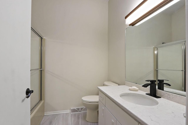 8124 W Imperial Dr, Franklin, WI 53132 - full bathroom with toilet, vanity, baseboards, and shower / bath combination with glass door