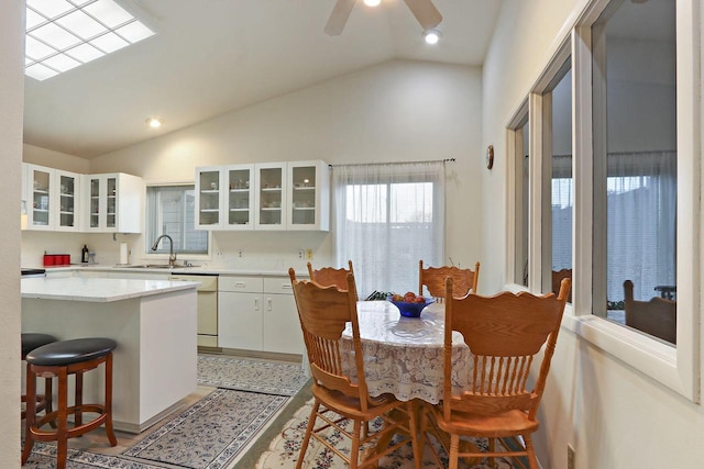 8124 W Imperial Dr, Franklin, WI 53132 - kitchen featuring dishwasher, vaulted ceiling, a sink, white cabinets, and light countertops