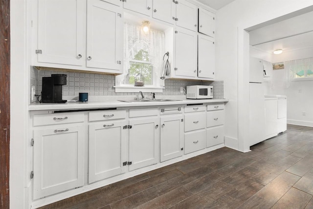 25 E 1st St, Clintonville, WI 54929 - kitchen featuring white microwave, light countertops, independent washer and dryer, decorative backsplash, and white cabinetry