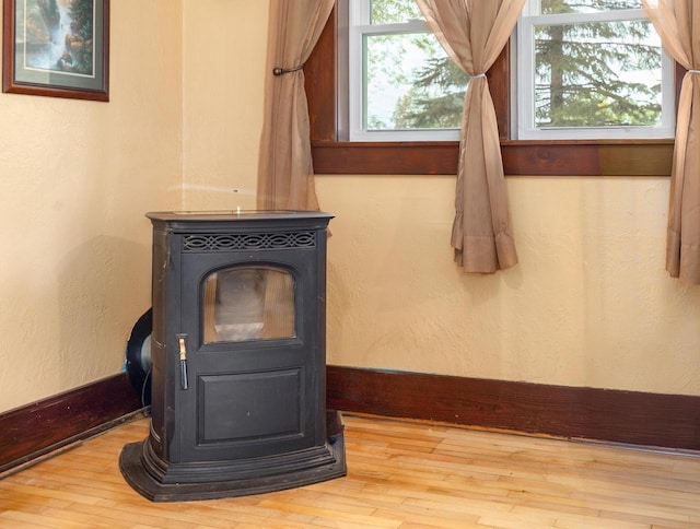 25 E 1st St, Clintonville, WI 54929 - detailed view of a wood stove, wood finished floors, baseboards, and a textured wall