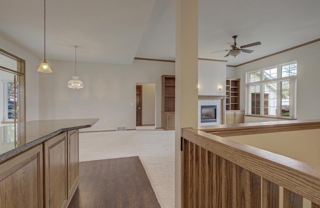 3205 N Mistwood Ln, Appleton, WI 54914 - kitchen featuring a tile fireplace, ceiling fan, dark carpet, decorative light fixtures, and ornamental molding