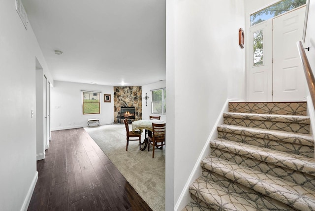 483 W S St Unit A, Lake Geneva, WI 53147 - staircase with hardwood / wood-style floors, a stone fireplace, and baseboards