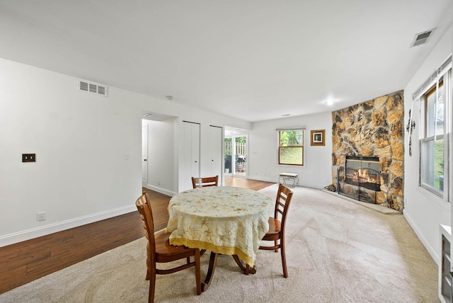 483 W S St Unit A, Lake Geneva, WI 53147 - dining area with wood finished floors, a stone fireplace, and baseboards