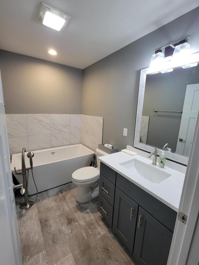 9435 402nd Ave, Genoa City, WI 53128 - bathroom with a soaking tub, vanity, wood finished floors, and toilet