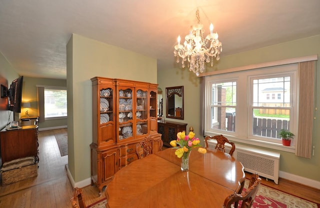 3524 Washington Ave, Racine, WI 53402 - dining area with radiator, a chandelier, wood finished floors, and baseboards
