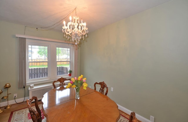 3524 Washington Ave, Racine, WI 53402 - dining space featuring a chandelier, baseboards, radiator heating unit, and wood finished floors