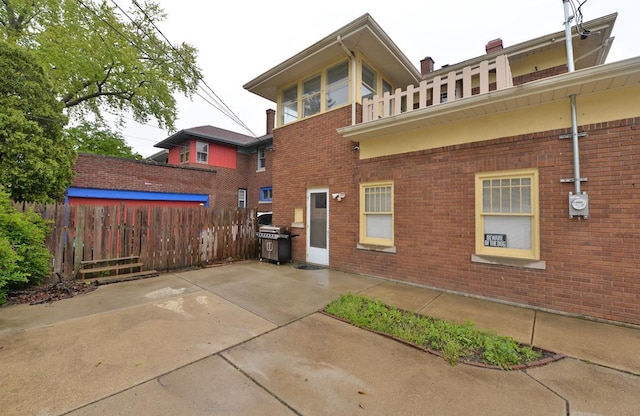 3524 Washington Ave, Racine, WI 53402 - rear view of house with brick siding, a patio area, a balcony, and a chimney