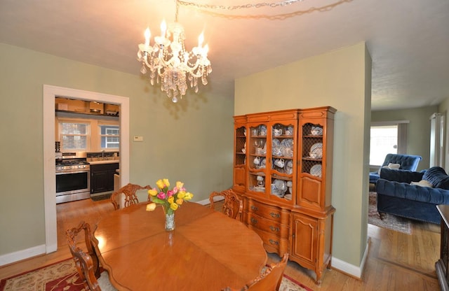 3524 Washington Ave, Racine, WI 53402 - dining room featuring light wood-type flooring, a chandelier, and baseboards