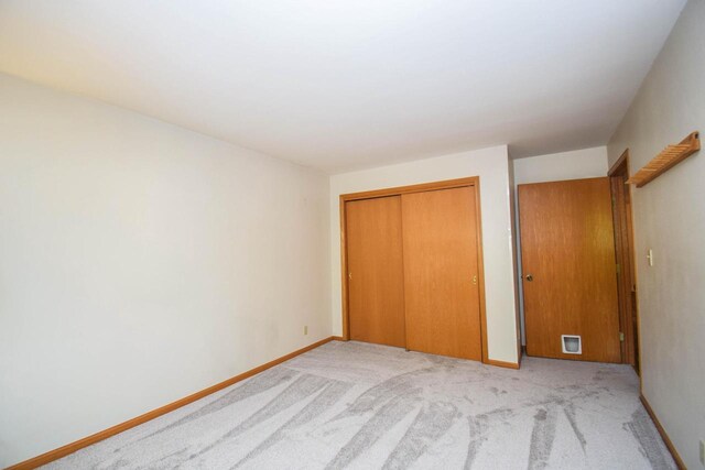 2116 Woodburn Rd Unit B, Waukesha, WI 53188 - unfurnished bedroom with a closet, light colored carpet, and baseboards