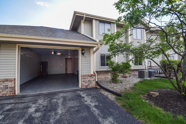 2116 Woodburn Rd Unit B, Waukesha, WI 53188 - view of front of home with driveway, an attached garage, and cooling unit