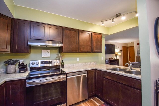 2116 Woodburn Rd Unit B, Waukesha, WI 53188 - kitchen featuring stainless steel appliances, under cabinet range hood, a sink, and light countertops