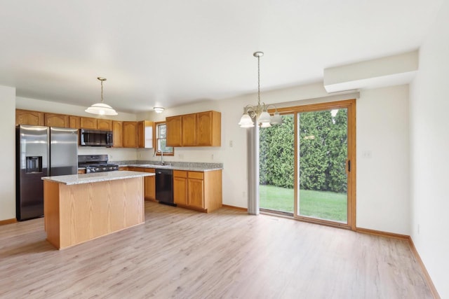 24434 88th St, Salem, WI 53168 - kitchen with appliances with stainless steel finishes, light wood-style flooring, baseboards, a center island, and decorative light fixtures