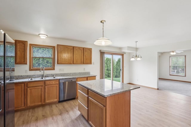 24434 88th St, Salem, WI 53168 - kitchen with stainless steel dishwasher, a sink, brown cabinets, light wood-style floors, and pendant lighting