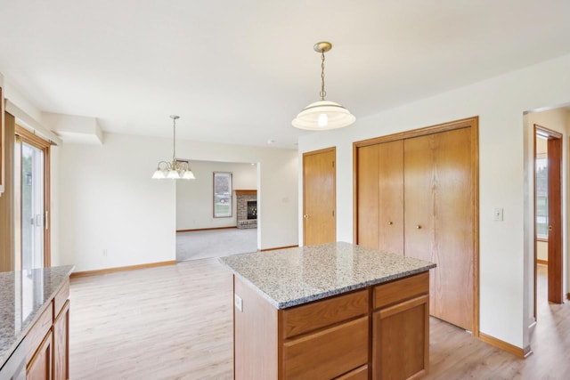 24434 88th St, Salem, WI 53168 - kitchen with light wood-style floors, baseboards, and decorative light fixtures