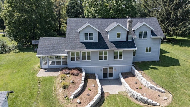 134 Tustin Rd, Fremont, WI 54940 - view of front of house featuring a front lawn, a sunroom, a shingled roof, and a chimney