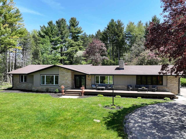 W207S8686 Hillendale Dr, Muskego, WI 53150 - view of front of property featuring stone siding, a chimney, a wooden deck, and a front yard