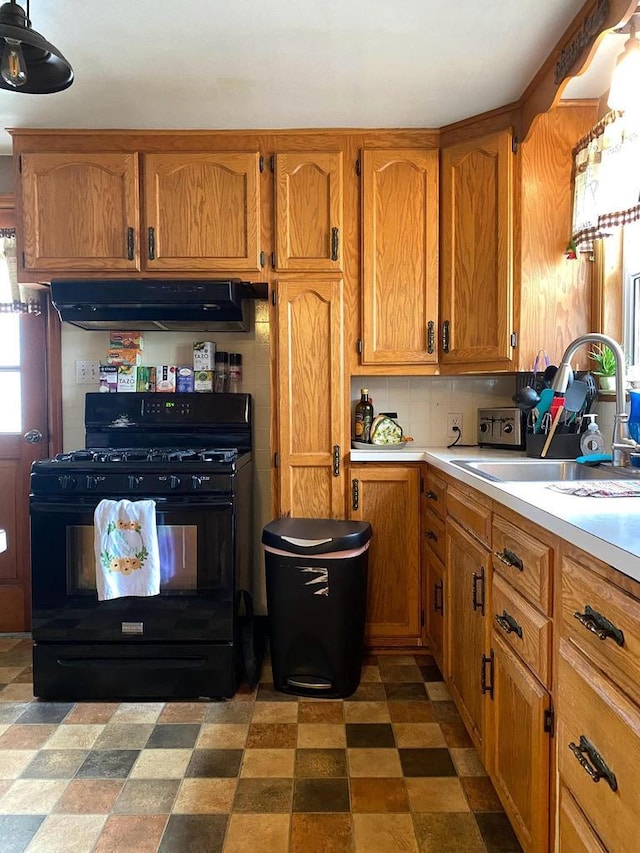 816 Gladstone St, Marinette, WI 54143 - kitchen featuring black gas range oven, under cabinet range hood, a sink, light countertops, and brown cabinets
