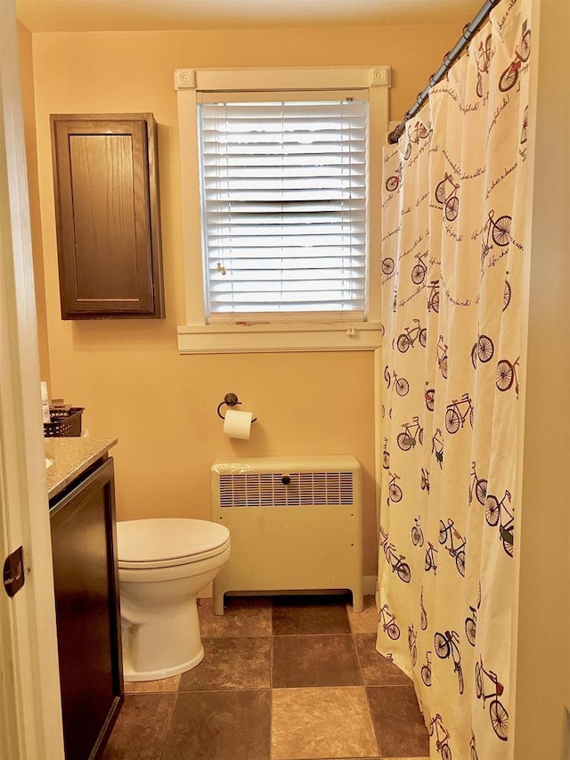 816 Gladstone St, Marinette, WI 54143 - bathroom with radiator heating unit, toilet, vanity, and curtained shower
