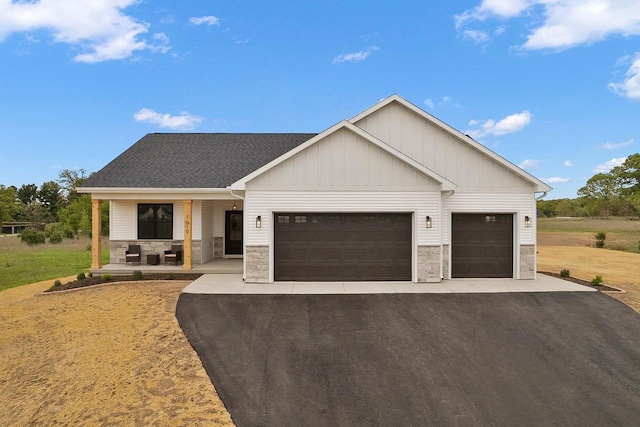 1619 Prairie Oak Dr, Wisconsin Dells, WI 53965 - modern farmhouse featuring stone siding, a garage, asphalt driveway, and board and batten siding
