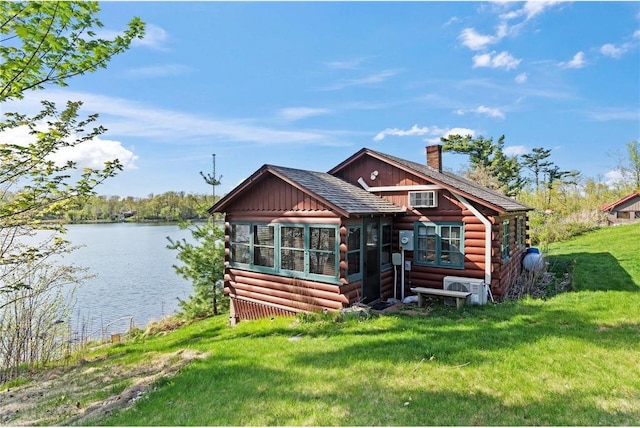 1949 E Little Blake Lake Ln, Luck, WI 54853 - view of front of house with a water view, log siding, a front lawn, and a chimney